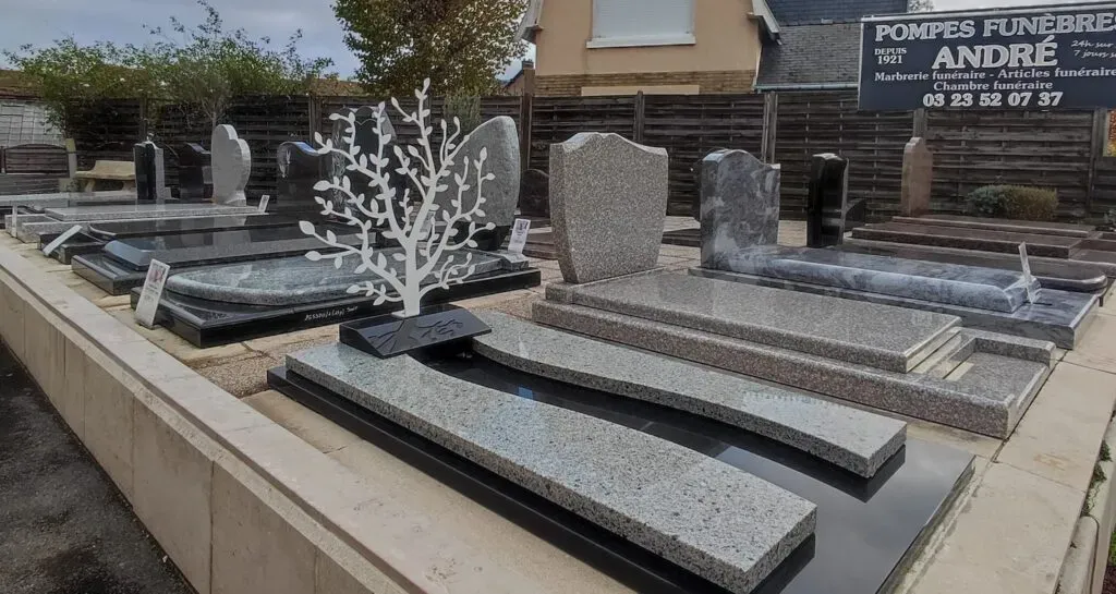 Alignement de stèles et monuments funéraires en vitrine extérieure.