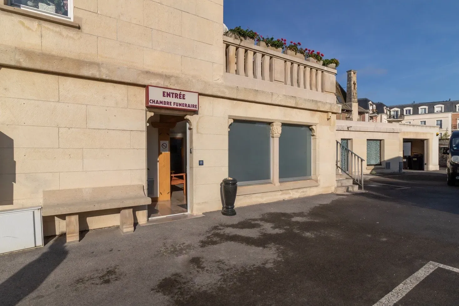 Entrée extérieure en pierre de taille d'une chambre funéraire avec banc et balustrade.